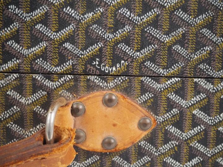 GOYARD Valise vintage en toile goyardine gainée de cuir marron.  Une a