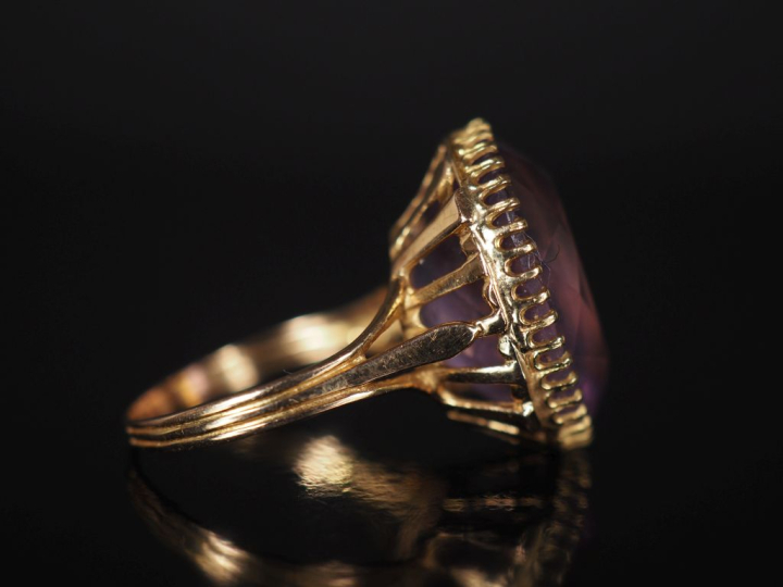 Bague en or jaune 750, sertie en son centre d'une améthyste. Jolie mon
