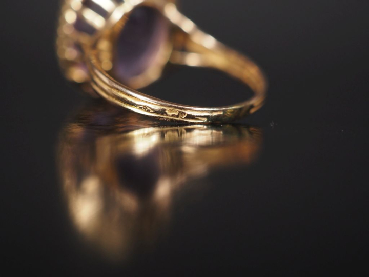 Bague en or jaune 750, sertie en son centre d'une améthyste. Jolie mon