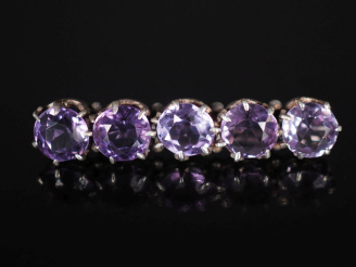 Vente aux enchères Broche barrette en argent, sertie de cinq améthystes (?). Long. 4,5 cm
