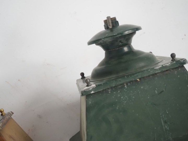 Une lanterne en fer forgé et laiton et une lanterne en tôle verte, les