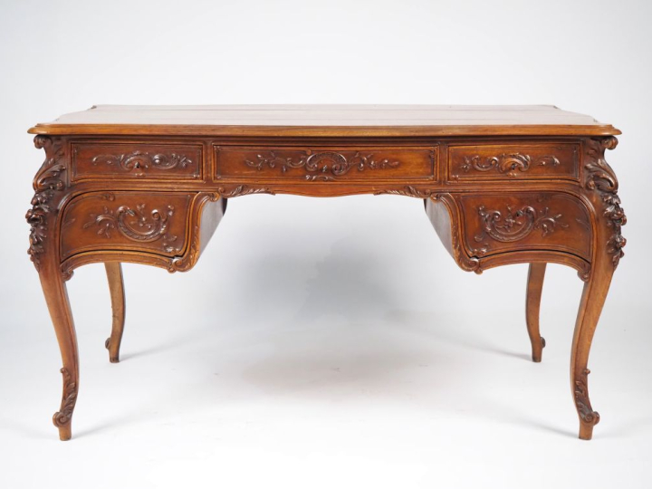 Bureau plat de style Louis XV en bois mouluré et sculpté, à décor de r