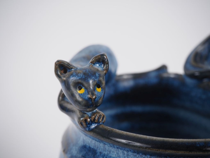 Vase en grès flammé bleu, à décor en relief de chat couché. Monogrammé