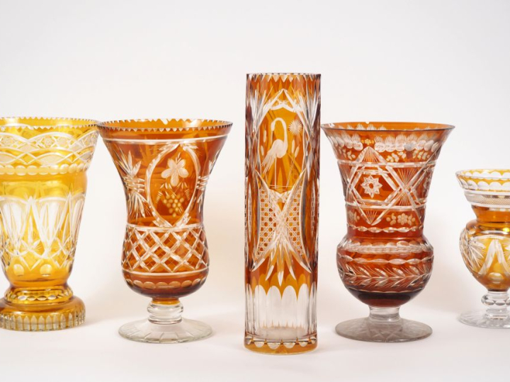 5 différents vases en cristal ou verre ambré et translucide, à décor d