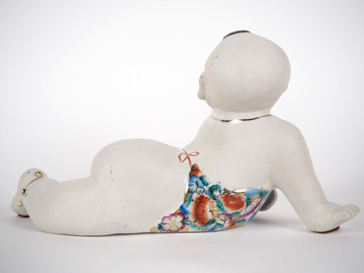 Sujet chinois en biscuit et porcelaine émaillée polychrome.  "bébé chi