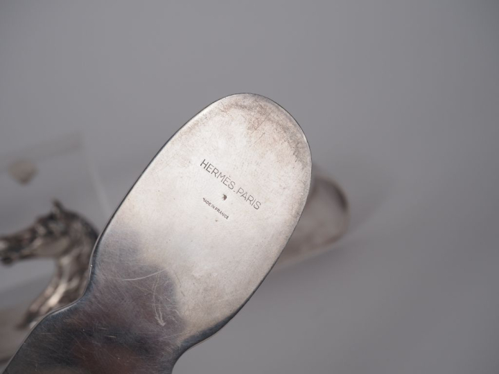 HERMES.  Garniture de bureau en métal argenté à décor de tête de cheva