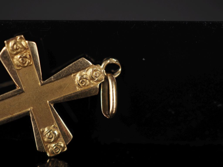 Pendentif en or jaune 750 en forme de croix, à décor de roses.  3,8 x 