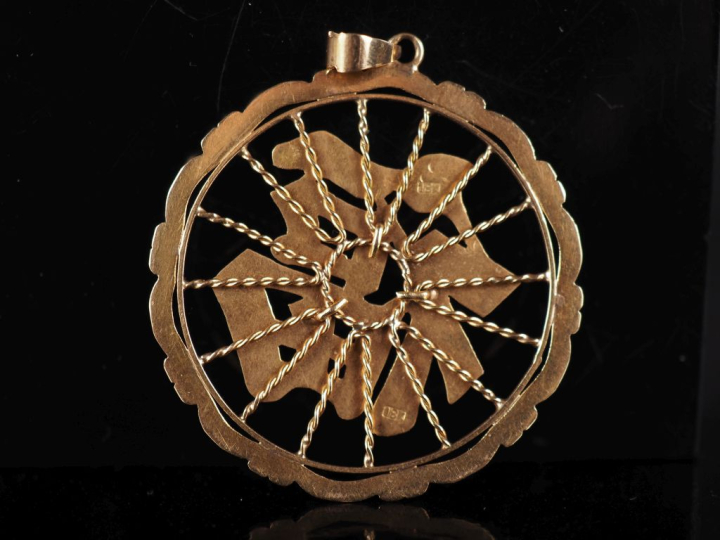 Pendentif ajouré en or jaune 750, à décor de caractère.  Diam. 4 cm Po