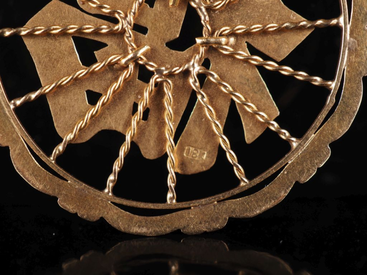 Pendentif ajouré en or jaune 750, à décor de caractère.  Diam. 4 cm Po