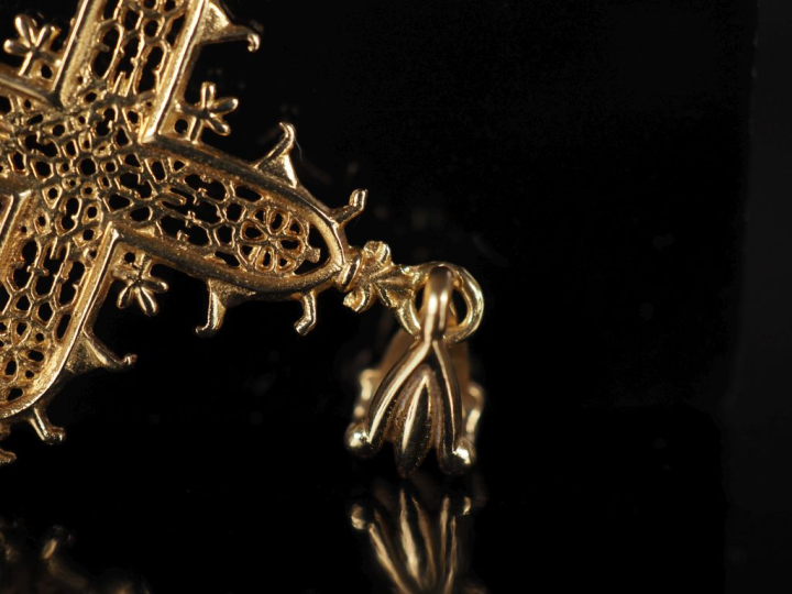 Pendentif en forme de croix en or jaune 750, à décor ajouré. 5 x 3 cm 