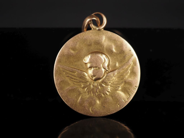 Médaille religieuse en or jaune 750, figurant un angelot dans les nuée