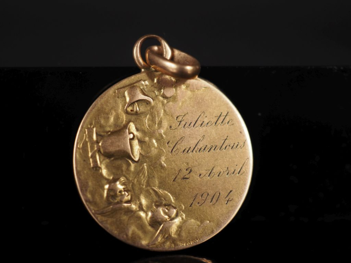 Médaille religieuse en or jaune 750, figurant un angelot dans les nuée