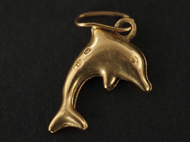 Petit pendentif en or jaune 750, en forme de dauphin.  H. 1,2 cm Poids