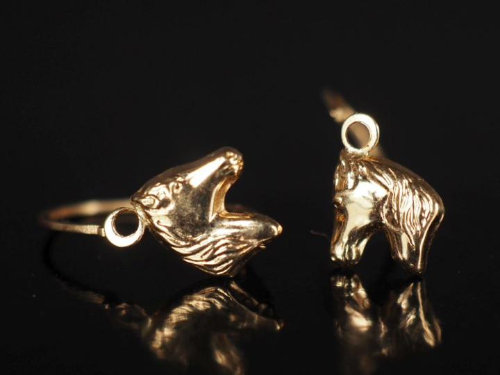 Paire de perces oreilles en or jaune 750, à décor de cheval. H. 1,5 cm