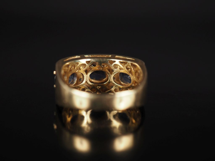 Bague bandeau en or jaune 750, sertie de trois saphirs entourés d'un p