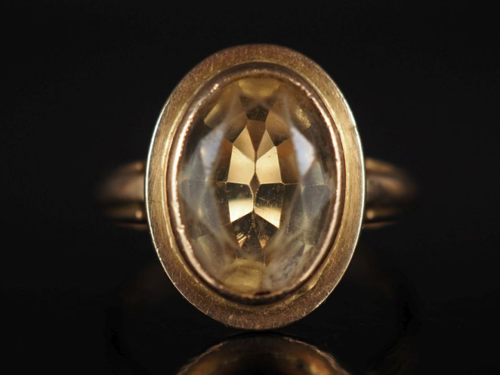 Bague en or jaune 750, ornée en son centre d'un quartz jaune serti clo