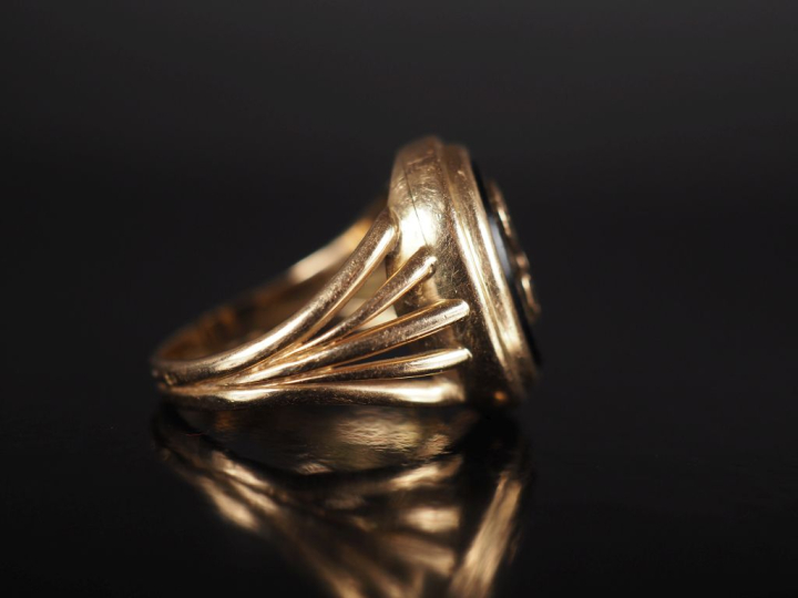 Bague de forme chevalière en or jaune 750 et onyx noir, à décor de mon