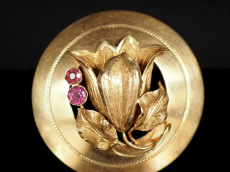 Vente aux enchères Broche ronde en or jaune 750, à décor ajouré d'une fleur et agrémentée