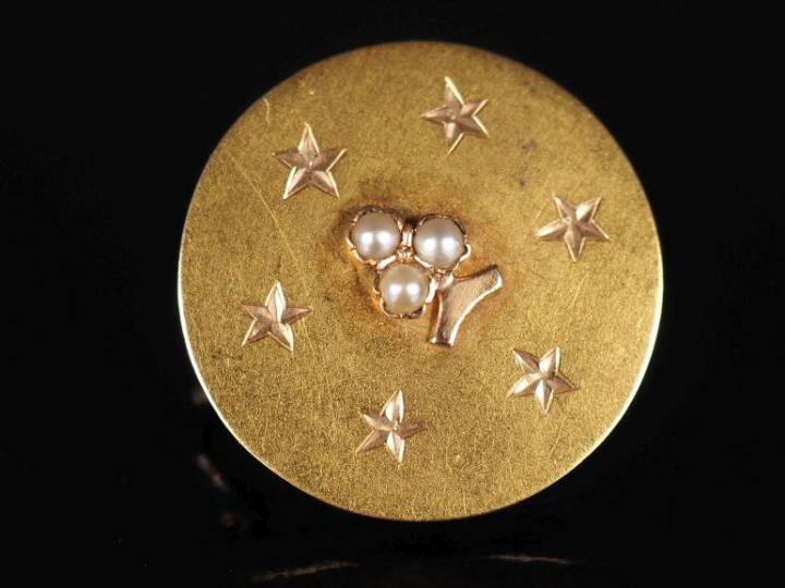 Broche ronde en or jaune 750, à décor en son centre d'un trèfle à troi