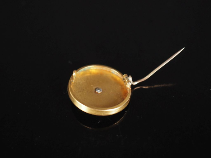 Broche ronde en or jaune 750, à décor en son centre d'un trèfle à troi