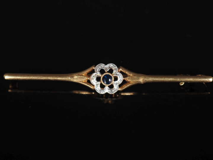 Broche barrette en or jaune 750, à décor en son centre d'une fleur ser
