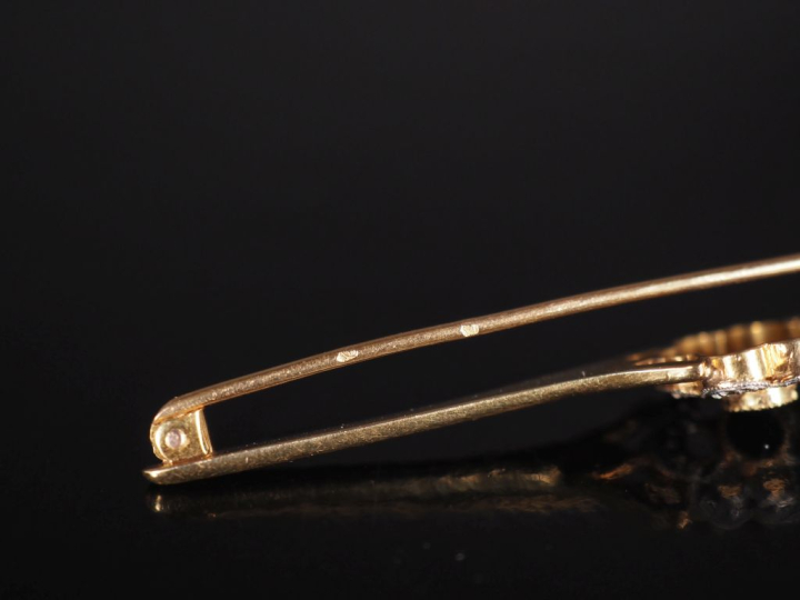 Broche barrette en or jaune 750, à décor en son centre d'une fleur ser