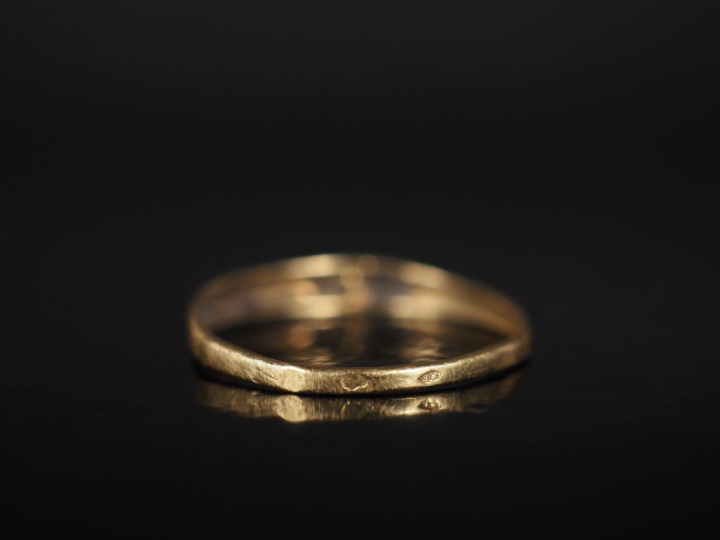 Petite bague jonc en or jaune 750, sertie en son centre d'une pierre. 