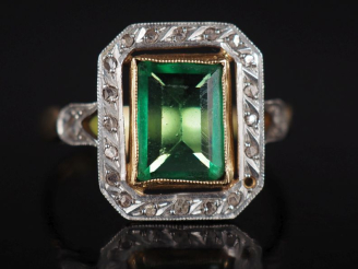 Vente aux enchères Bague en or jaune 750, sertie en son centre d'une pierre verte entouré