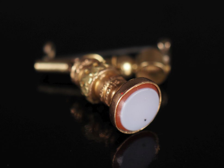 Clé de montre en métal doré ou plaqué or montée en broche et agrémenté