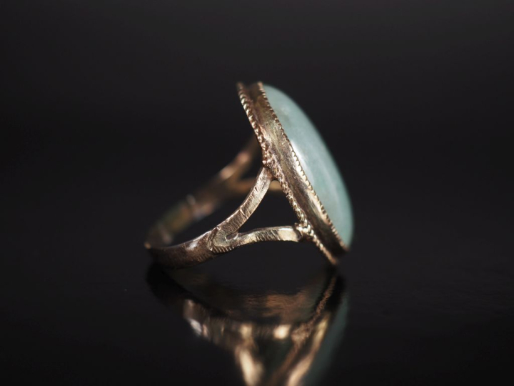 Bague en or jaune 375, sertie en son centre de jadéite en cabochon.  T