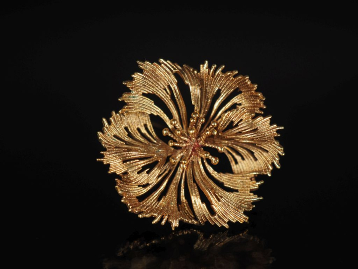 Broche en plaqué or en forme de fleur épanouie.