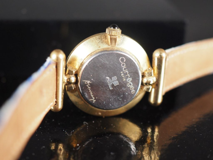 COURREGES Montre bracelet de dame. Cadran rond à pastilles pour les he