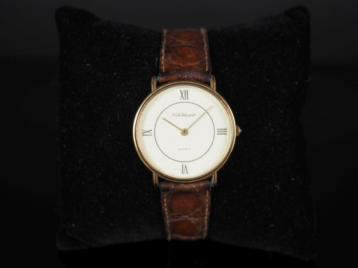 EMILE PEQUIGNET Montre bracelet en métal doré.  Cadran rond à chiffres