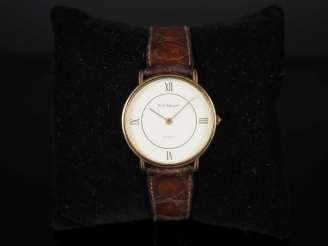 Vente aux enchères EMILE PEQUIGNET Montre bracelet en métal doré.  Cadran rond à chiffres