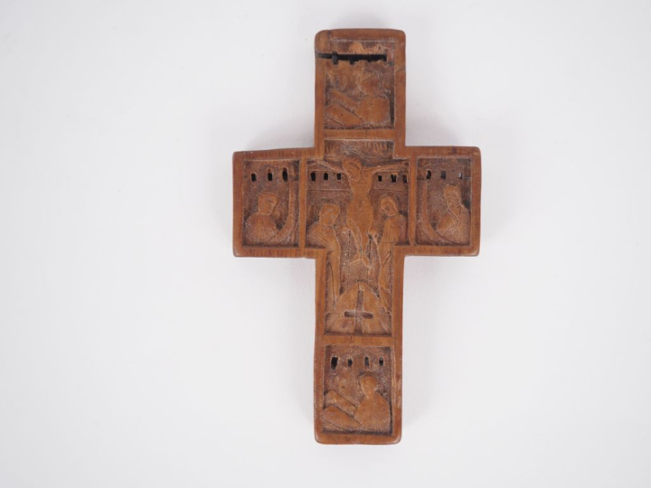 Croix en buis sculpté, un ex voto en laiton en forme de cœur enflammé,