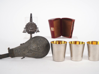 Vente aux enchères Lot comprenant : - une poire à poudre en laiton et métal repoussé figu