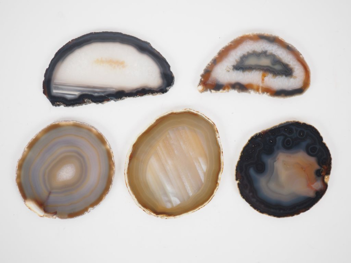 Cinq tranches d'agate naturelles. H. de 6 à 9 cm.  On y joint une obél
