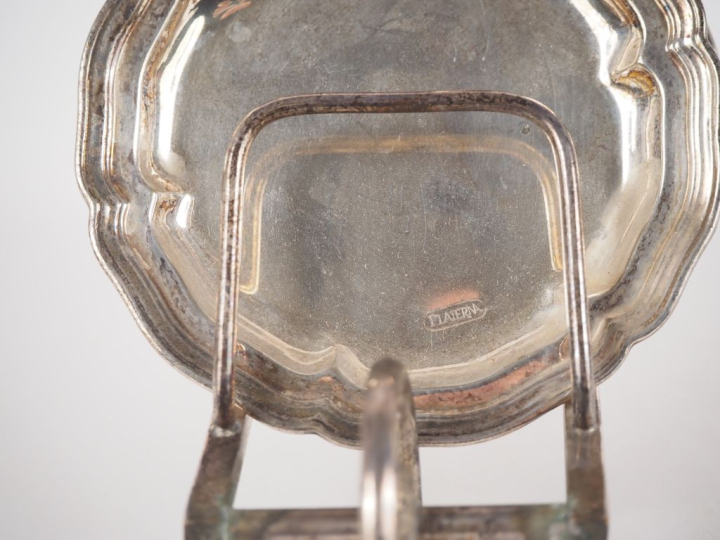 Cinq dessous de verre en métal argenté sur un support figurant une bro