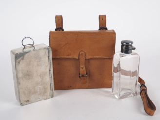 Vente aux enchères Sacoche en cuir brun contenant une boîte en métal argenté et un flacon