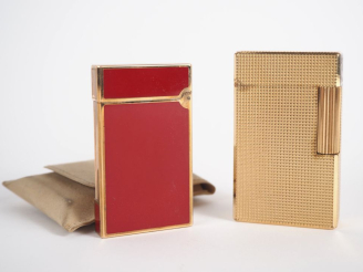 Vente aux enchères DUPONT. Deux différents briquets en métal doré, l'un laqué rouge. Sign