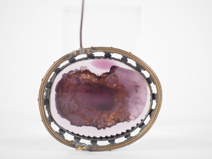 Broche 1900 en pâte de verre figurant un profil de jeune femme en reli