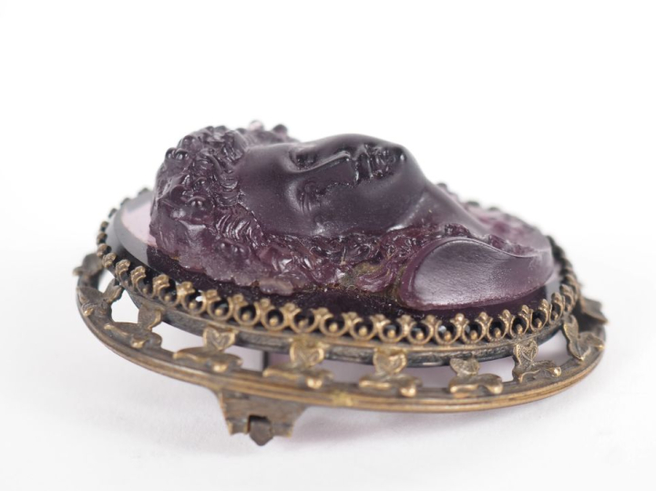 Broche 1900 en pâte de verre figurant un profil de jeune femme en reli