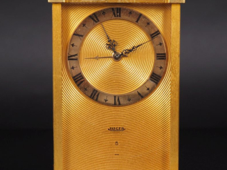Vente aux enchères JAEGER, 8 jours Pendulette de table en métal doré, à décor de cercles 