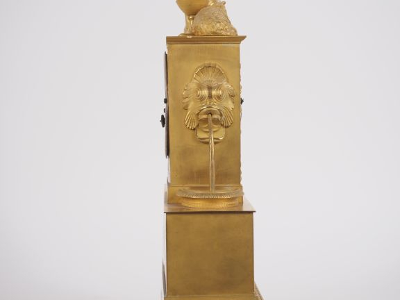 Pendule Restauration en bronze doré "jeune femme à l'antique et son ag