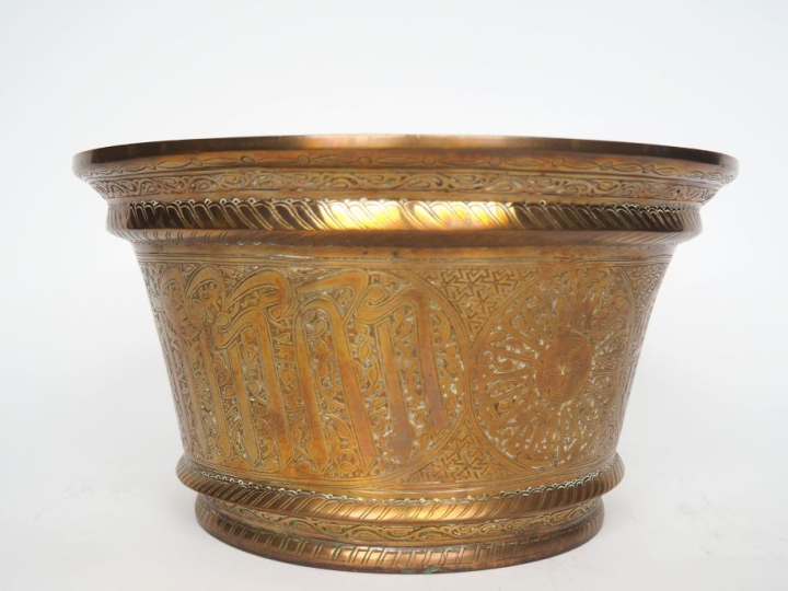 Socle arabe en bronze, à décor de motifs caligraphiés. H. 16,5 cm