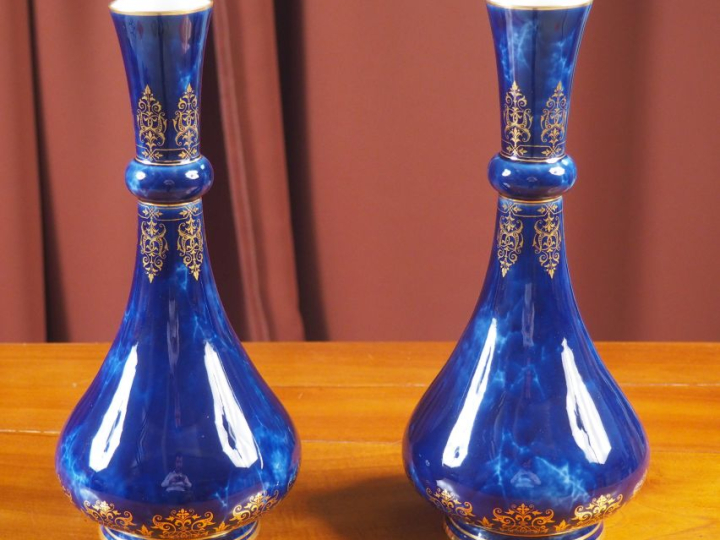 SÈVRES.  Paire de vases en porcelaine, à décor de rinceaux dorés et de