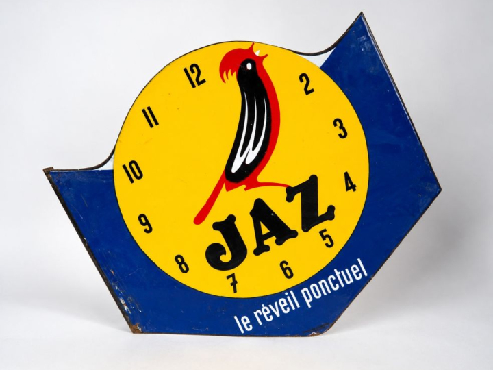 Plaque émaillée double face JAZ "le réveil ponctuel". Dim. 49 x 55 cm
