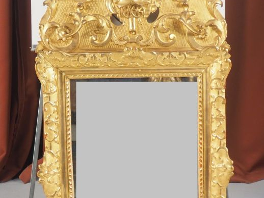 Glace Louis XV en bois sculpté et doré, à décor de rinceaux feuillagés